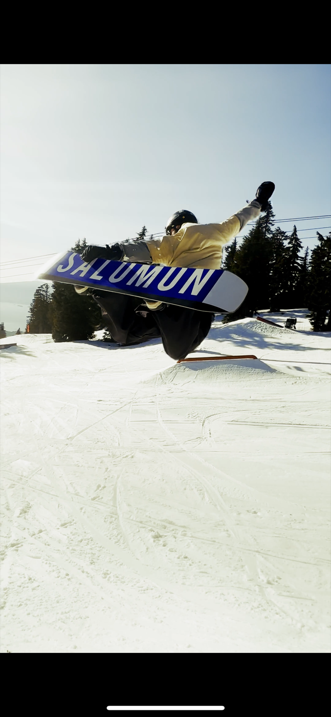 Ben snowboarding, mid air off a jump